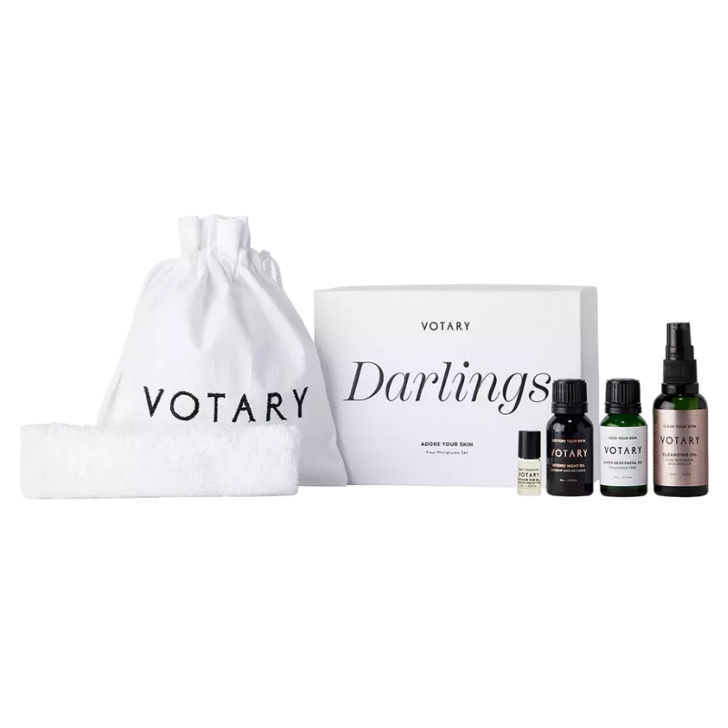 VOTARY Darlings Boxed Set: Handtuch, Beutel, und vier Hautpflegeprodukte in Flaschen vor weißem Hintergrund.